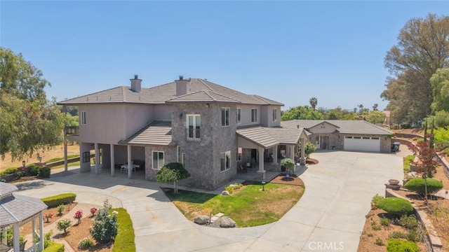 38855 Bella Vista Rd, Temecula, CA 92592 - view of front of property with concrete driveway, stone siding, a chimney, and a garage