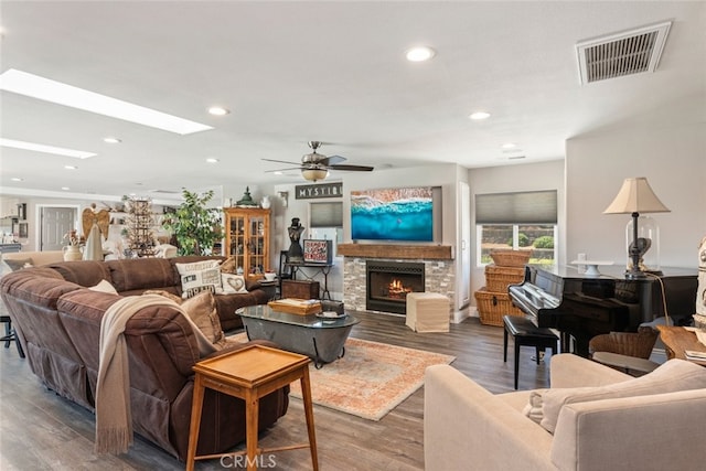 38855 Bella Vista Rd, Temecula, CA 92592 - living area with a stone fireplace, recessed lighting, a ceiling fan, wood finished floors, and a skylight
