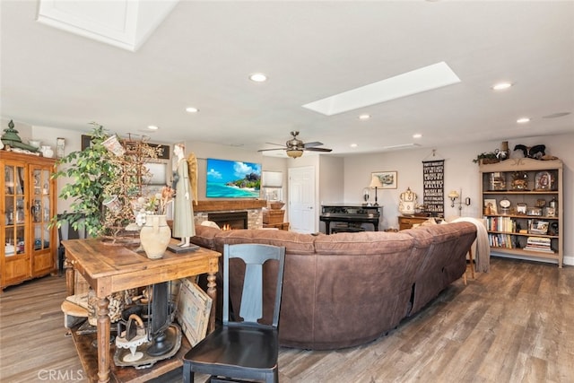 38855 Bella Vista Rd, Temecula, CA 92592 - living room with a skylight, wood finished floors, ceiling fan, recessed lighting, and a warm lit fireplace