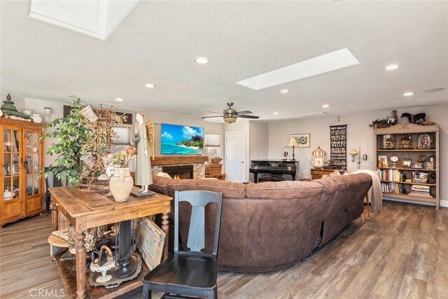 38855 Bella Vista Rd, Temecula, CA 92592 - living room with a skylight, wood finished floors, a ceiling fan, recessed lighting, and a lit fireplace