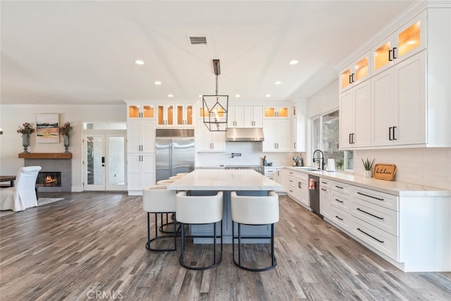 38855 Bella Vista Rd, Temecula, CA 92592 - kitchen with stainless steel appliances, under cabinet range hood, a sink, a center island, and tasteful backsplash