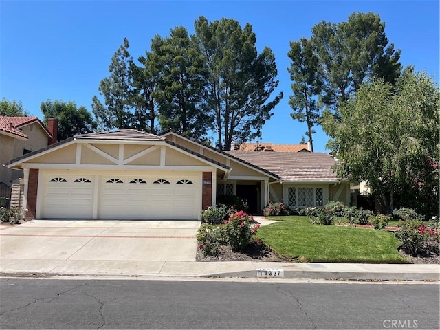 view of front of home with a garage, driveway, a front lawn, and stucco siding