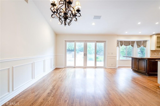 18337 Chatham Ln, Porter Ranch, CA 91326 - unfurnished living room with a decorative wall, light wood finished floors, french doors, a chandelier, and wainscoting
