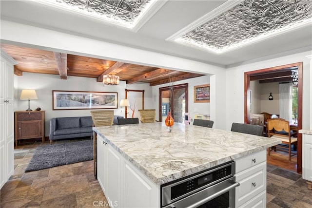 1961 Forester Creek Rd, El Cajon, CA 92021 - kitchen with dark stone finish floors, oven, open floor plan, white cabinetry, and light stone countertops