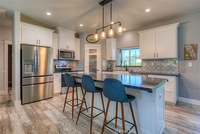 5981 Kibler Rd, Paradise, CA 95969 - kitchen featuring appliances with stainless steel finishes, light wood-type flooring, a center island, white cabinetry, and recessed lighting