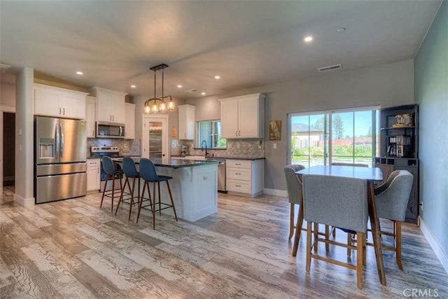 5981 Kibler Rd, Paradise, CA 95969 - kitchen with appliances with stainless steel finishes, dark countertops, a kitchen island, a breakfast bar, and tasteful backsplash