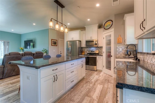 5981 Kibler Rd, Paradise, CA 95969 - kitchen with stainless steel appliances, a sink, light wood-type flooring, open floor plan, and white cabinetry