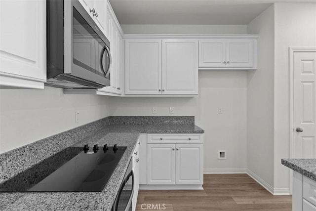 30773 Vera Cruz Cir, Winchester, CA 92596 - kitchen featuring stainless steel microwave, white cabinetry, black electric stovetop, and light wood-style flooring