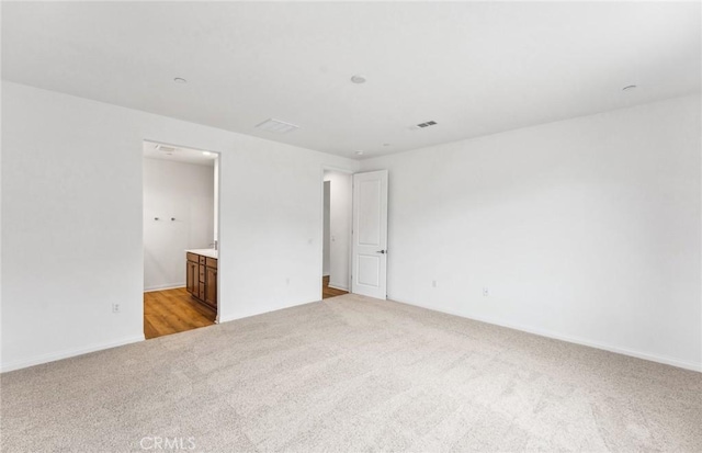 4180 Larchwood Ln, Lake Elsinore, CA 92530 - unfurnished bedroom featuring light carpet, connected bathroom, and baseboards