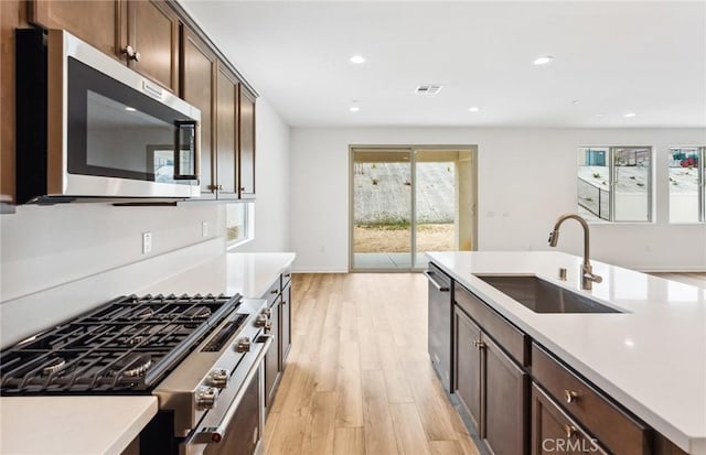 4180 Larchwood Ln, Lake Elsinore, CA 92530 - kitchen with stainless steel appliances, a sink, light wood-style flooring, light countertops, and recessed lighting