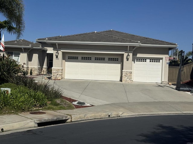 508 Hidden Ridge Ct, Encinitas, CA 92024 - view of front facade with stone siding, driveway, stucco siding, and a garage