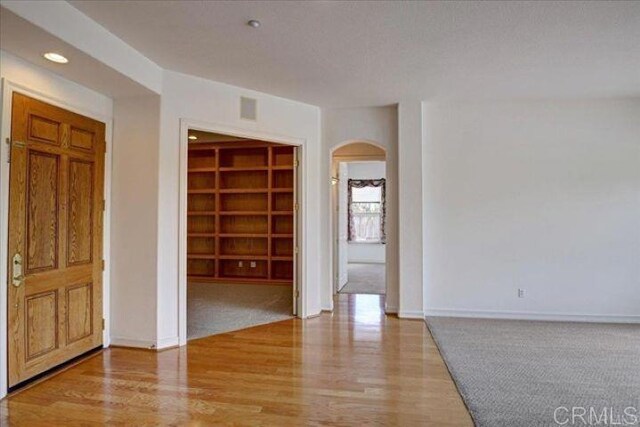 508 Hidden Ridge Ct, Encinitas, CA 92024 - spare room with arched walkways, wood finished floors, and recessed lighting