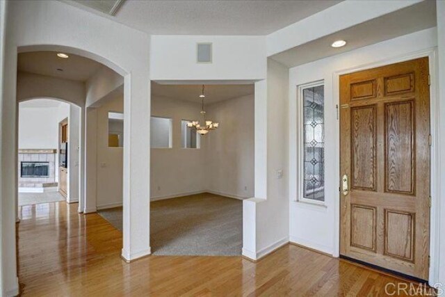 508 Hidden Ridge Ct, Encinitas, CA 92024 - foyer entrance featuring arched walkways, wood finished floors, and a chandelier