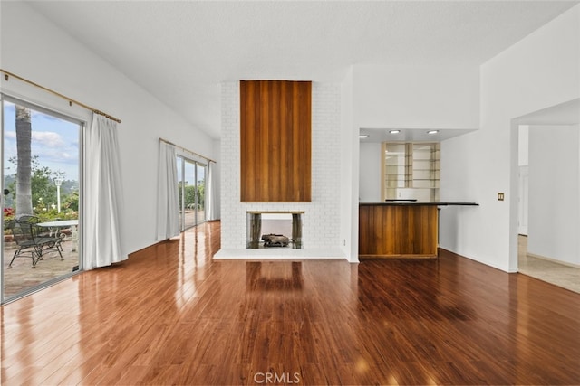 10835 Savona Rd, Los Angeles, CA 90077 - unfurnished living room featuring wood finished floors and a brick fireplace