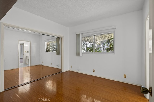 10835 Savona Rd, Los Angeles, CA 90077 - unfurnished bedroom featuring wood finished floors, a textured ceiling, and a closet