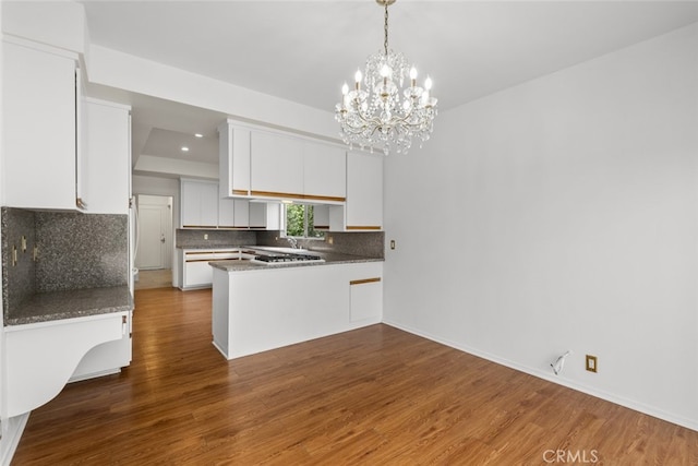 10835 Savona Rd, Los Angeles, CA 90077 - kitchen featuring a peninsula, white cabinetry, dark wood finished floors, tasteful backsplash, and a chandelier