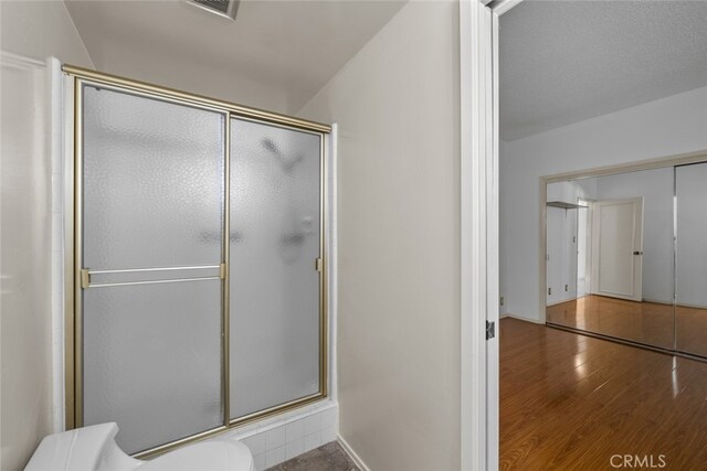 10835 Savona Rd, Los Angeles, CA 90077 - bathroom featuring toilet, a stall shower, and wood finished floors