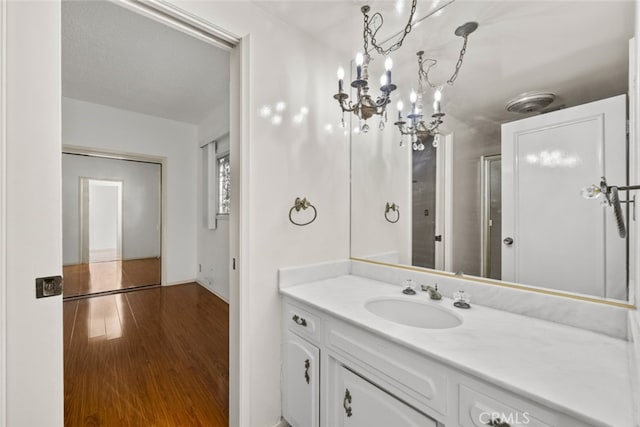 10835 Savona Rd, Los Angeles, CA 90077 - bathroom with wood finished floors, vanity, a chandelier, and baseboards