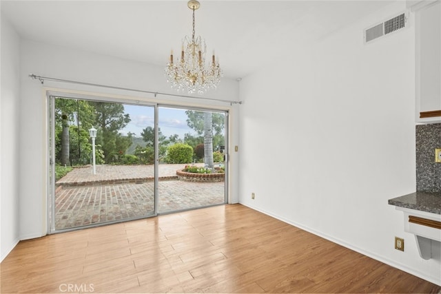 10835 Savona Rd, Los Angeles, CA 90077 - unfurnished dining area featuring a chandelier, plenty of natural light, wood finished floors, and baseboards