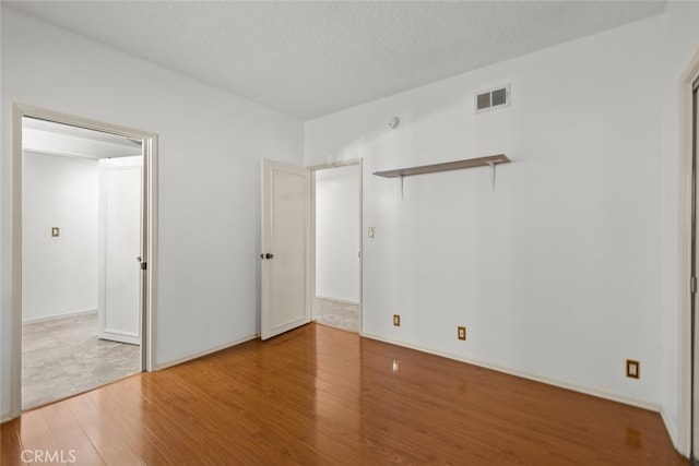 10835 Savona Rd, Los Angeles, CA 90077 - unfurnished bedroom featuring wood finished floors and a textured ceiling