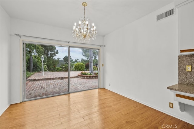 10835 Savona Rd, Los Angeles, CA 90077 - unfurnished dining area with light wood-style flooring, a chandelier, plenty of natural light, and baseboards