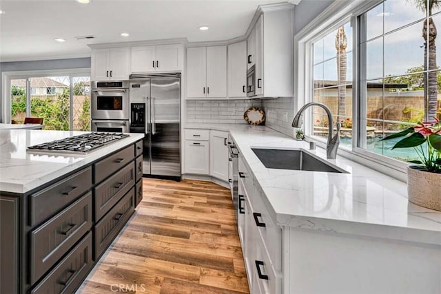 21772 Windsong Cir, Huntington Beach, CA 92646 - kitchen featuring built in appliances, a sink, white cabinetry, decorative backsplash, and recessed lighting