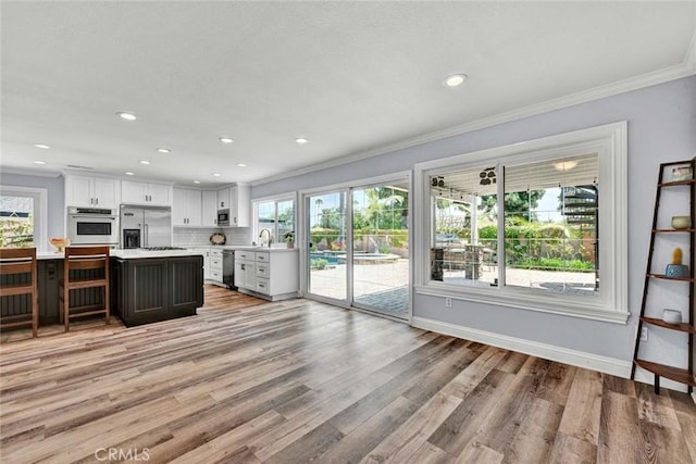 21772 Windsong Cir, Huntington Beach, CA 92646 - kitchen with light countertops, a sink, appliances with stainless steel finishes, ornamental molding, and healthy amount of natural light