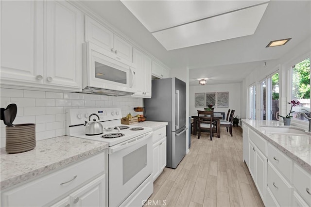23706 Mill Valley Rd, Valencia, CA 91355 - kitchen with white appliances, a sink, white cabinetry, tasteful backsplash, and light stone countertops