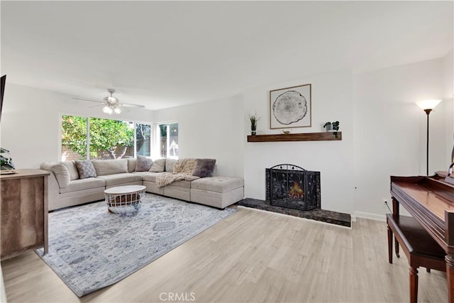 23706 Mill Valley Rd, Valencia, CA 91355 - living room featuring light wood-style floors, ceiling fan, and a lit fireplace