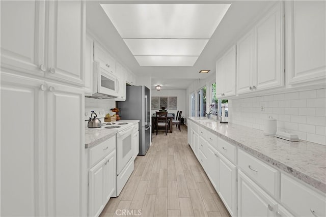 23706 Mill Valley Rd, Valencia, CA 91355 - kitchen with white appliances, white cabinets, backsplash, and light stone countertops