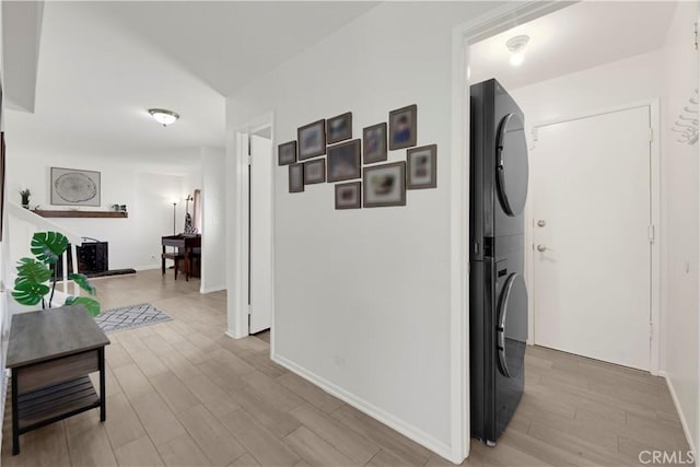23706 Mill Valley Rd, Valencia, CA 91355 - hallway featuring stacked washer / drying machine, light wood-type flooring, and baseboards