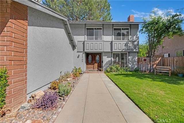 23706 Mill Valley Rd, Valencia, CA 91355 - view of exterior entry with stucco siding, a chimney, and french doors