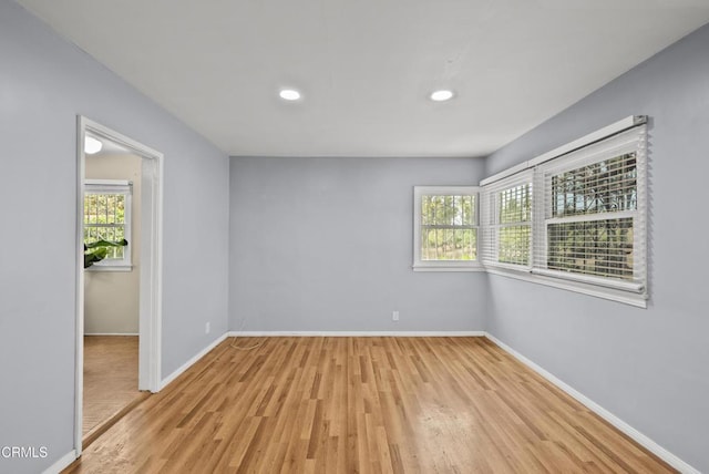 unfurnished room featuring baseboards, light wood finished floors, healthy amount of natural light, and recessed lighting