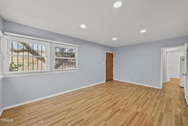 unfurnished room featuring baseboards, light wood finished floors, and recessed lighting