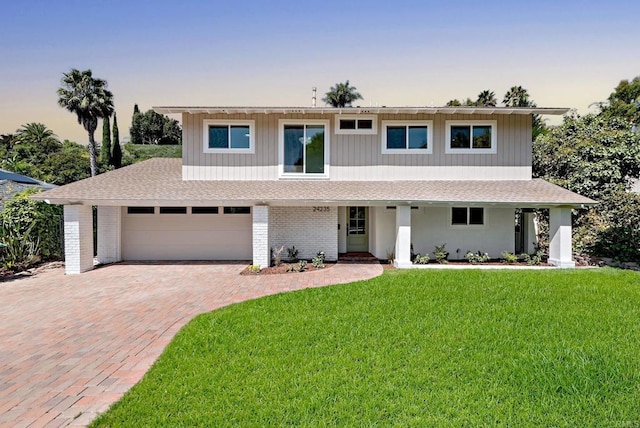 24235 Via Aquara Ave, Laguna Niguel, CA 92677 - view of front of property featuring roof with shingles, covered porch, a front yard, and decorative driveway