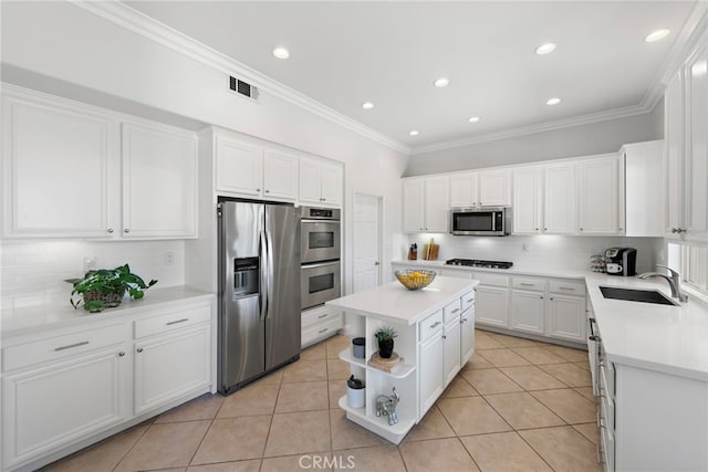 43 Flintridge, Ladera Ranch, CA 92694 - kitchen featuring appliances with stainless steel finishes, a sink, tasteful backsplash, white cabinets, and crown molding