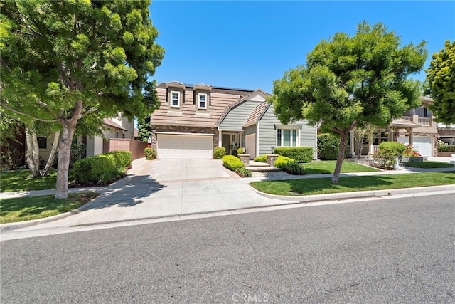 43 Flintridge, Ladera Ranch, CA 92694 - view of front facade featuring driveway, an attached garage, a front lawn, and stone siding