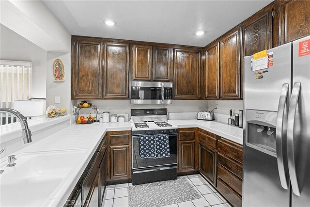 4856 W Glen Abbey Way, Banning, CA 92220 - kitchen featuring stainless steel appliances, a sink, light tile patterned floors, light countertops, and dark brown cabinets