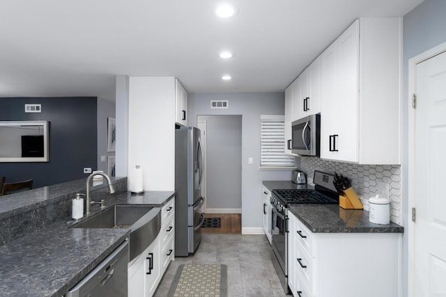 3696 Ben St, San Diego, CA 92111 - kitchen with stainless steel appliances, a sink, white cabinets, recessed lighting, and tasteful backsplash