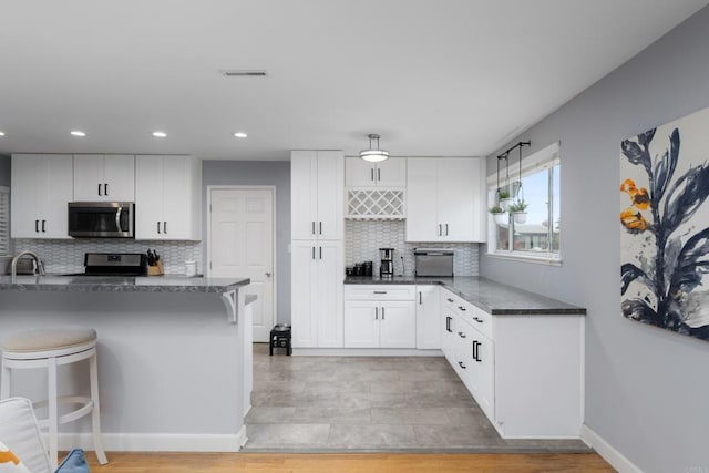 3696 Ben St, San Diego, CA 92111 - kitchen featuring stainless steel appliances, a kitchen breakfast bar, backsplash, white cabinetry, and recessed lighting
