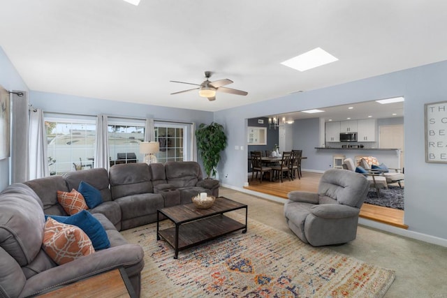 3696 Ben St, San Diego, CA 92111 - living room with baseboards, a ceiling fan, a skylight, and light colored carpet