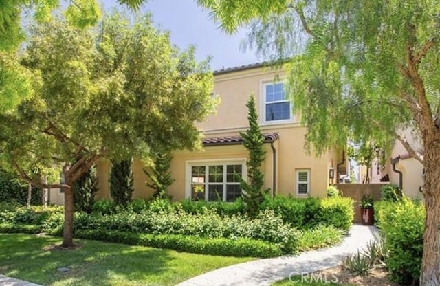 rear view of property with stucco siding and a lawn