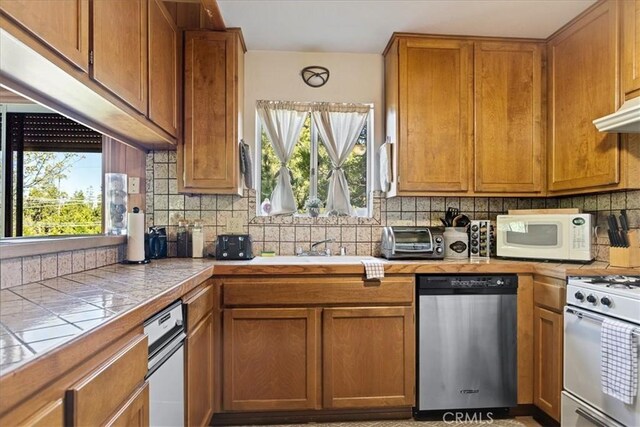 267 Pioneer Rd, Lake Arrowhead, CA 92317 - kitchen featuring white appliances, tile counters, decorative backsplash, brown cabinetry, and under cabinet range hood
