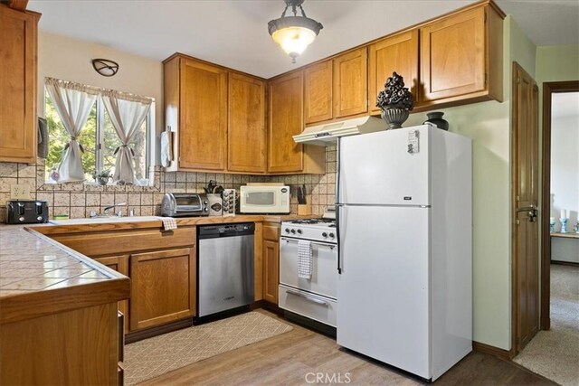 267 Pioneer Rd, Lake Arrowhead, CA 92317 - kitchen with white appliances, brown cabinetry, tasteful backsplash, light wood-type flooring, and tile countertops