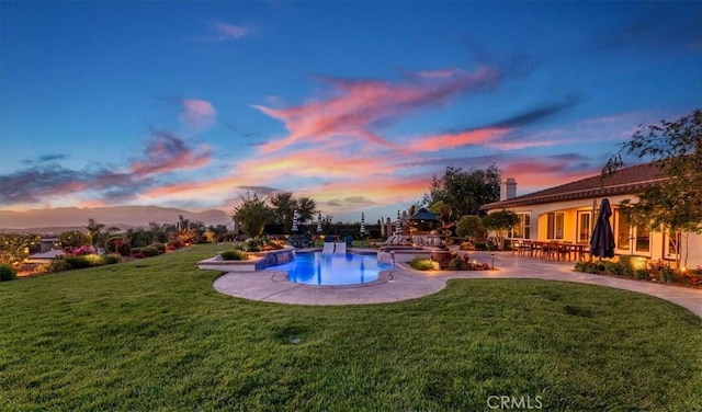 outdoor pool with a yard and a patio area