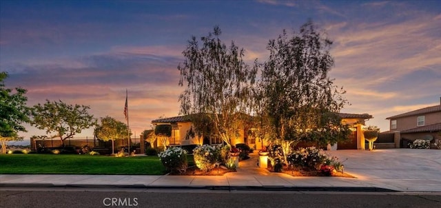 view of front of home featuring a lawn and concrete driveway