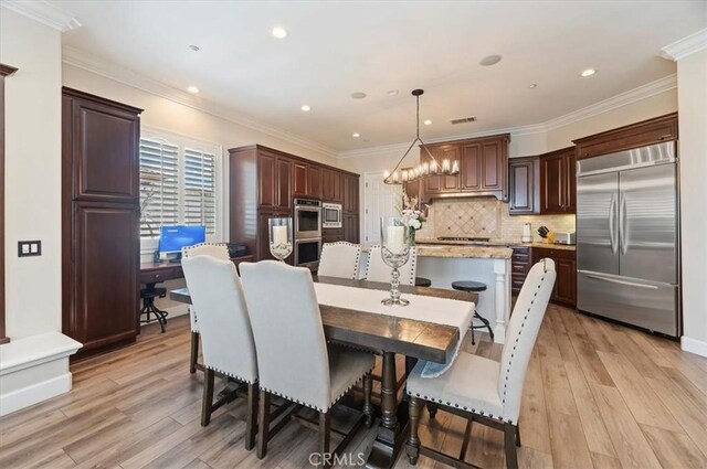 dining room with light wood-type flooring, ornamental molding, recessed lighting, and a chandelier