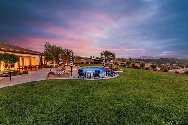 view of green lawn featuring a patio and an outdoor pool