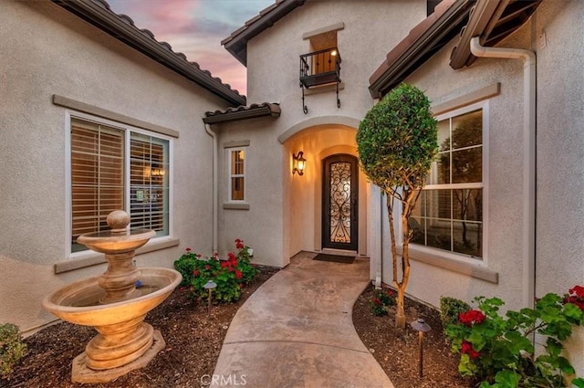 exterior entry at dusk with stucco siding