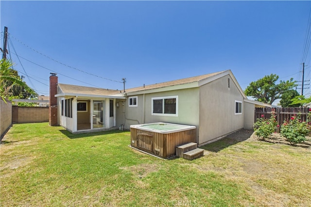 rear view of property with a hot tub